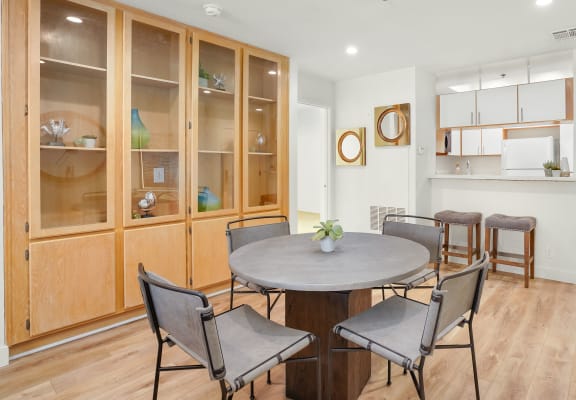 Apartment dining room area with a circular table with four chairs and built-in cabinets