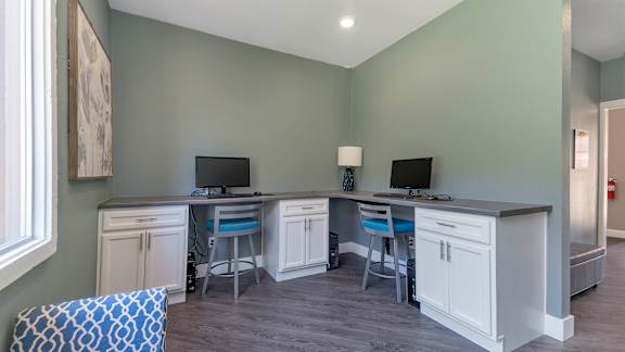 A room with two desks and a chair.