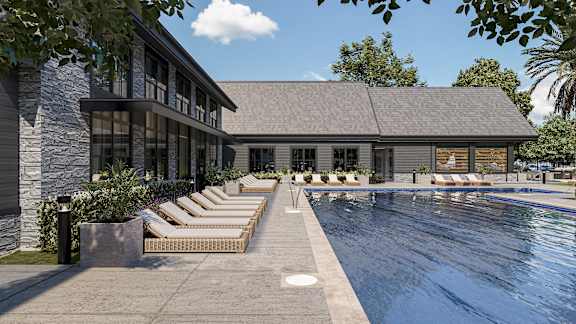 A pool area with sun loungers and a building in the background at The Pullman Luxury Apartment Homes, Atlanta, GA 30349