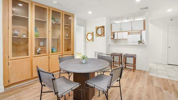 Apartment dining room area with a circular table with four chairs and built-in cabinets