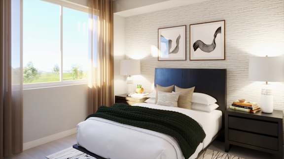 A bedroom with a large bed, a nightstand, and two wall lamps.