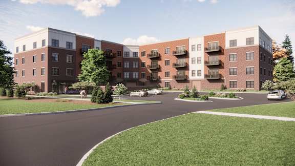 A modern apartment complex with a curved driveway in front.