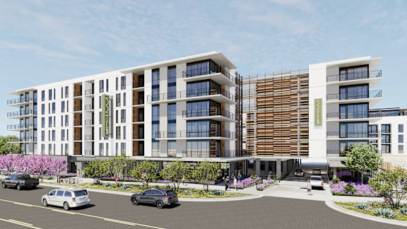 A modern building with a parking lot in front.