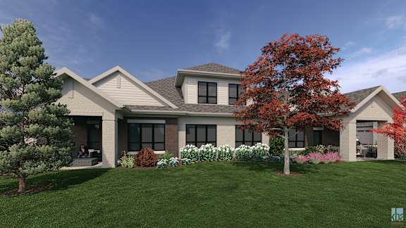 A house with a grey roof and a tree with red leaves in front of it.