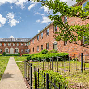 A long brick building with a walkway in front.
