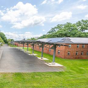 A long building with a green lawn in front.
