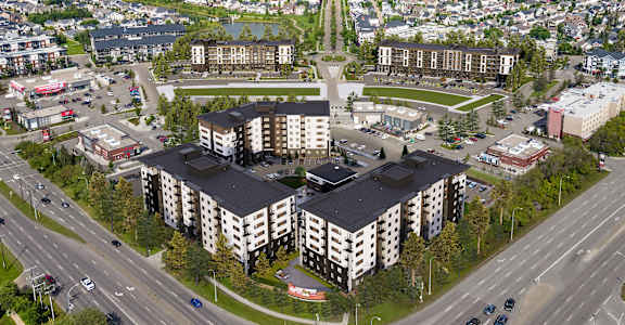 A large building complex with a parking lot in front.