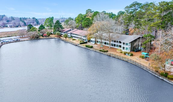 A serene lake with a building on the side and trees surrounding the area.