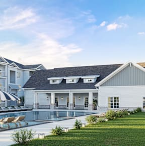 A white house with a pool in front of it.at The Landings at Hard Scrabble, Columbia
