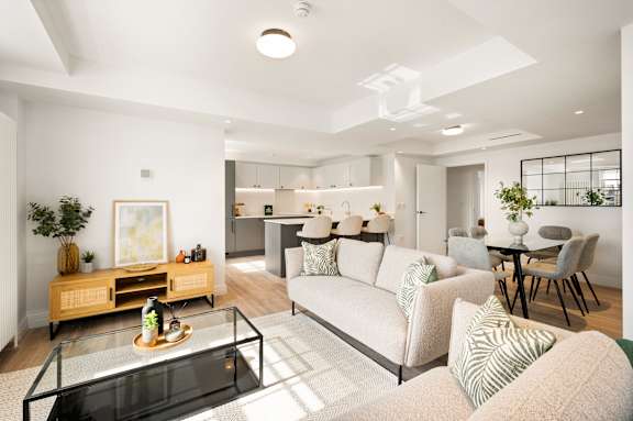 A modern living room with a glass coffee table and a white sofa.