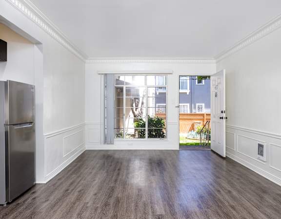a living room with a large window and a door to a balcony