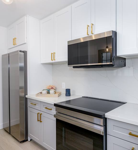 a laundry room with white appliances and white cabinets