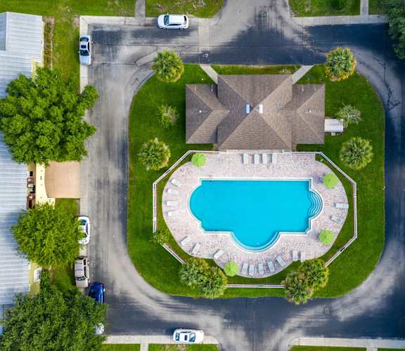 A bird's eye view of a residential area with a swimming pool and houses.