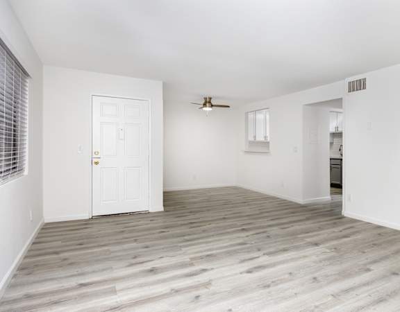 an empty living room with white walls and a white door