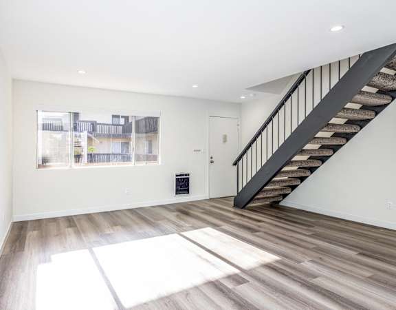 a living room with a staircase and a window