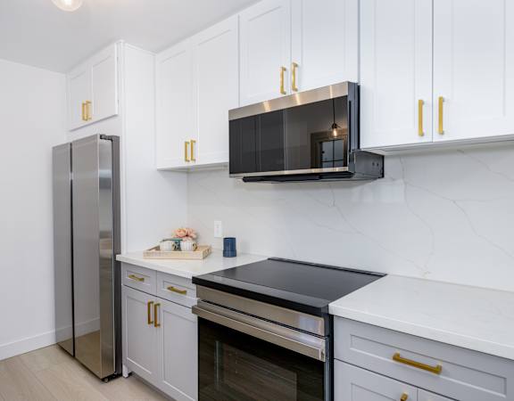 a kitchen with white cabinets and a stainless steel refrigerator