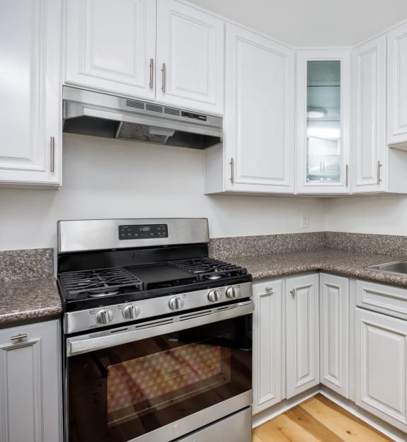 a kitchen with white cabinets and stainless steel appliances