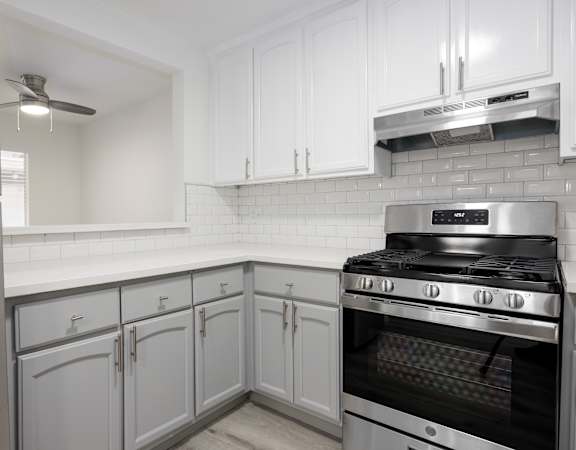a kitchen with white cabinets and stainless steel appliances