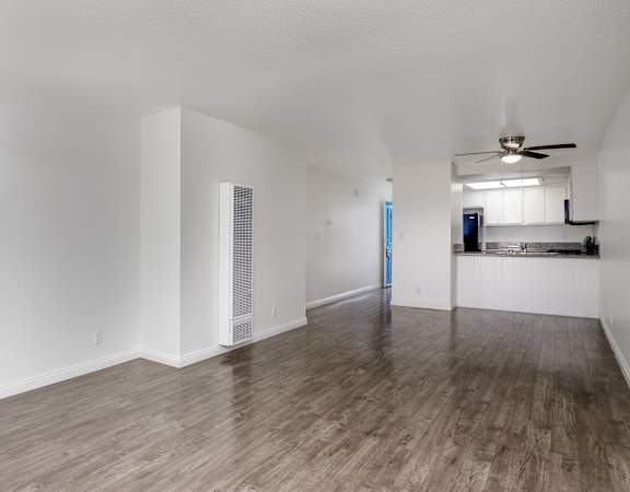 an empty living room with white walls and wood flooring