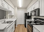 Thumbnail 6 of 19 - A kitchen with white cabinets and black appliances. at Highland Park, Texas, 76132