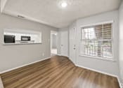 Thumbnail 11 of 19 - A room with a wooden floor and a window with blinds. at Highland Park, Texas, 76132