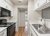 Thumbnail 10 of 19 - A kitchen with a stove, sink, and cabinets. at Highland Park, Texas, 76132