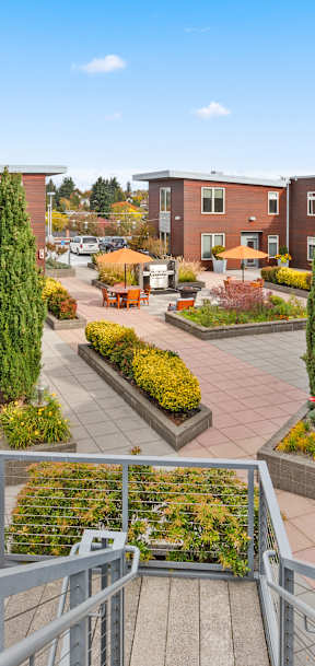 A view of a courtyard with a metal railing in the foreground.