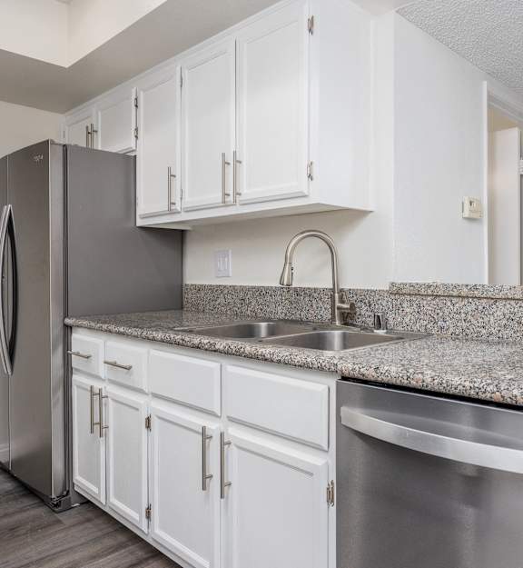 a kitchen with white cabinets and a stainless steel refrigerator