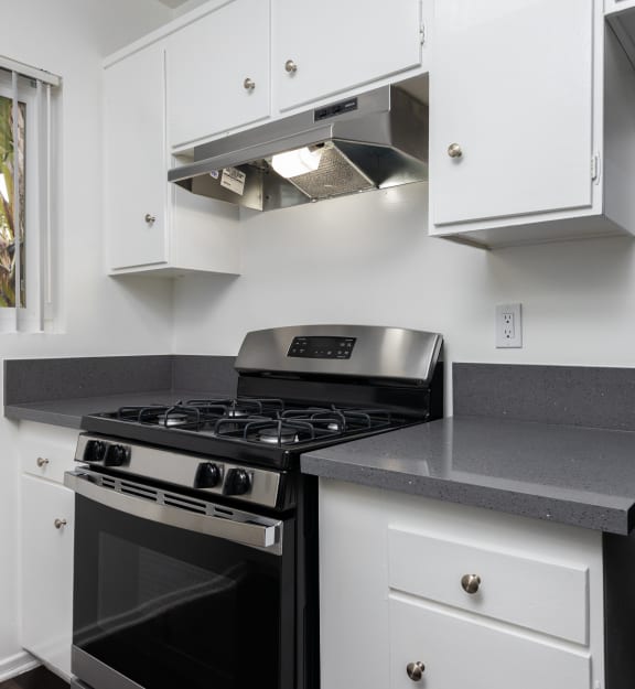 a kitchen with white cabinetry and black appliances
