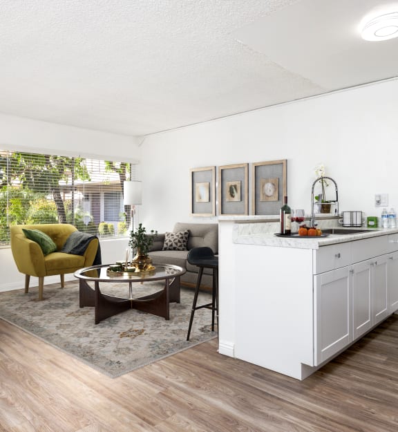 an empty living room and kitchen with a ceiling fan