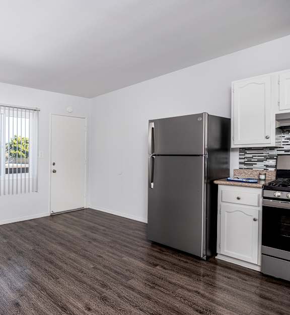 A kitchen with a refrigerator, oven, and microwave.