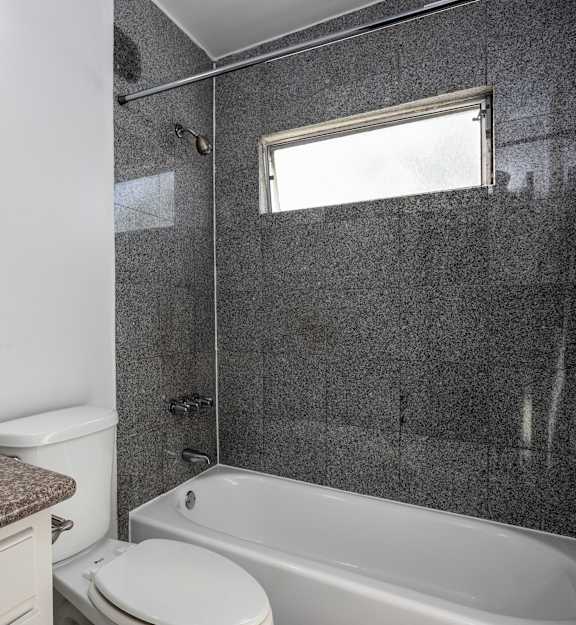 A bathroom with a sink, toilet, and bathtub.