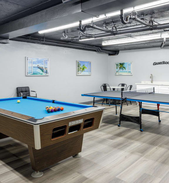two pool tables and two ping pong tables in a room with other tables