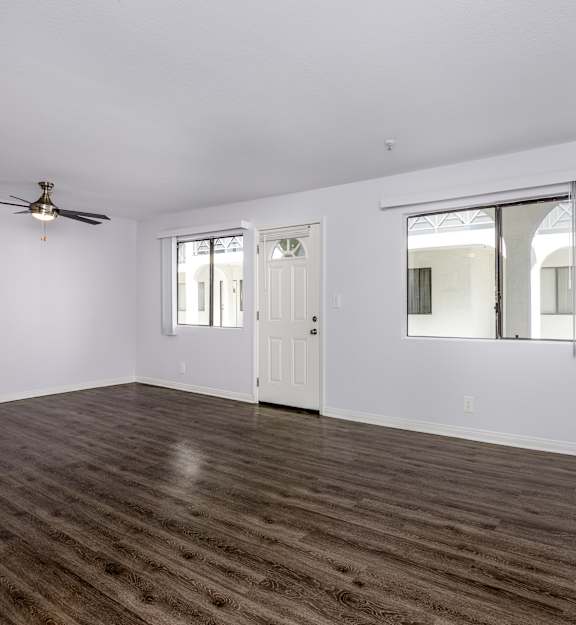 A room with a wooden floor and a ceiling fan.