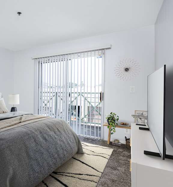 A bedroom with a large bed and a television on the side table.