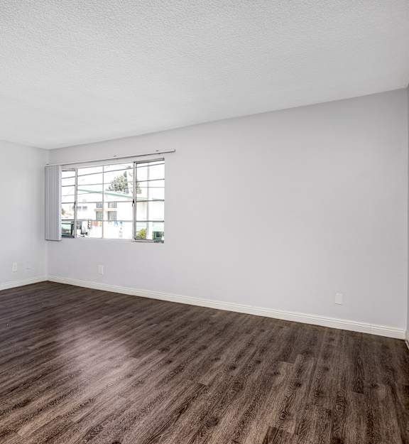 A room with wooden flooring and a window.