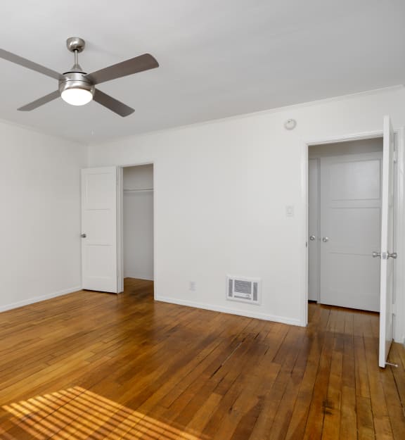 a living room with wood floors and a ceiling fan