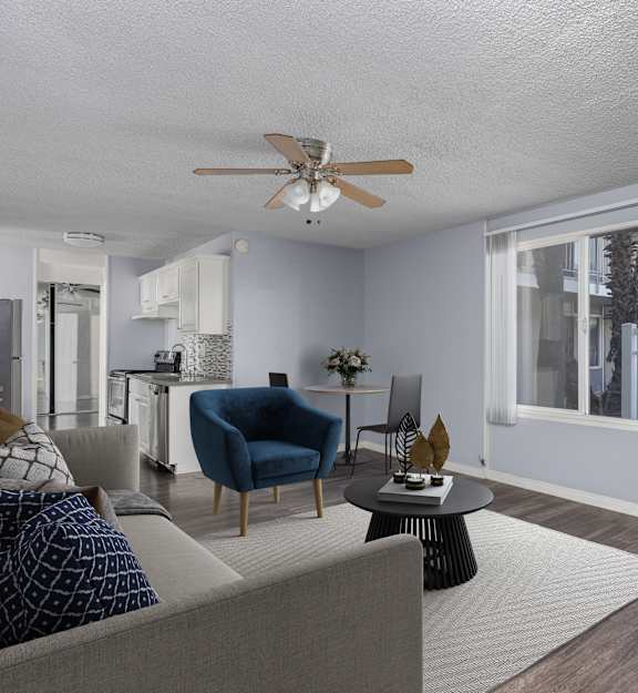 A room with a ceiling fan and sliding glass doors.