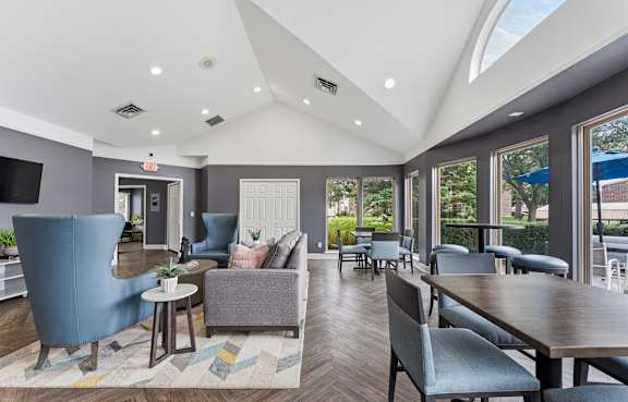 A clubhouse with a blue chair and a brown ottoman at Deerfield Woods Apartments, Michigan