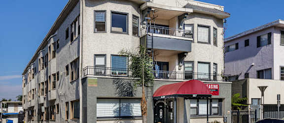 an apartment building on a city street with a red umbrella