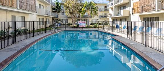 the swimming pool of an apartment building with a blue pool