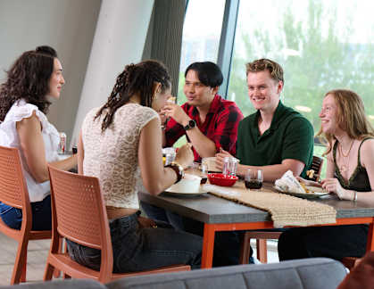 A group of people are sitting around a table having a meal.