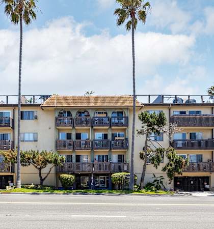 a large apartment building with balconies and palm trees