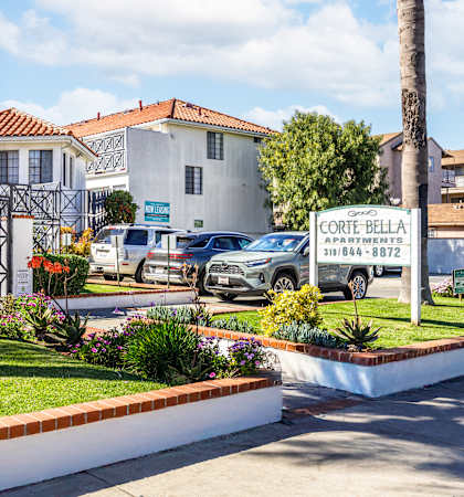 A white building with a sign that says Corte Bella in front of it.