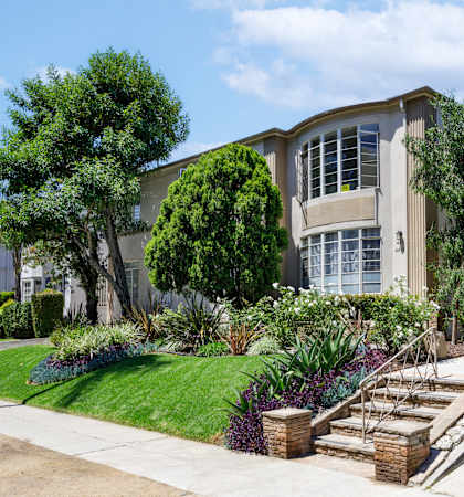 a house with stairs and a sidewalk in front of it