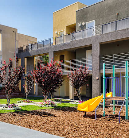 an outdoor playground in front of an apartment building