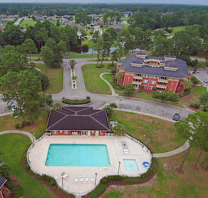 An aerial view of a resort with a swimming pool.