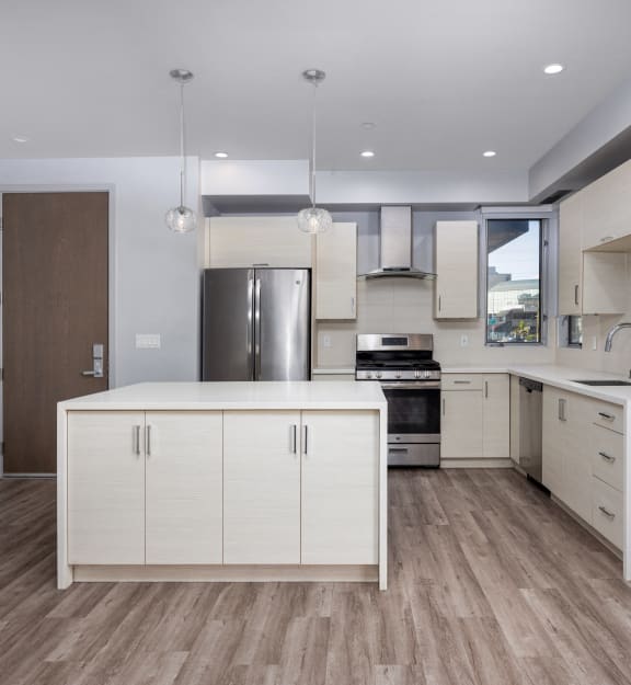 a kitchen with white cabinets and stainless steel appliances