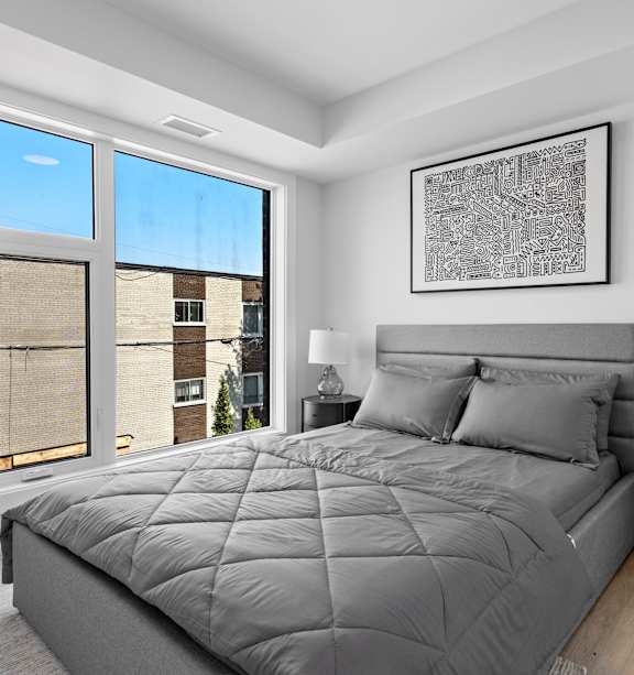 A bedroom with a large bed and a painting of a pool scene on the wall.