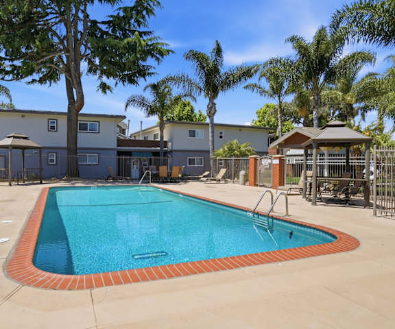 A swimming pool surrounded by a fence and trees.